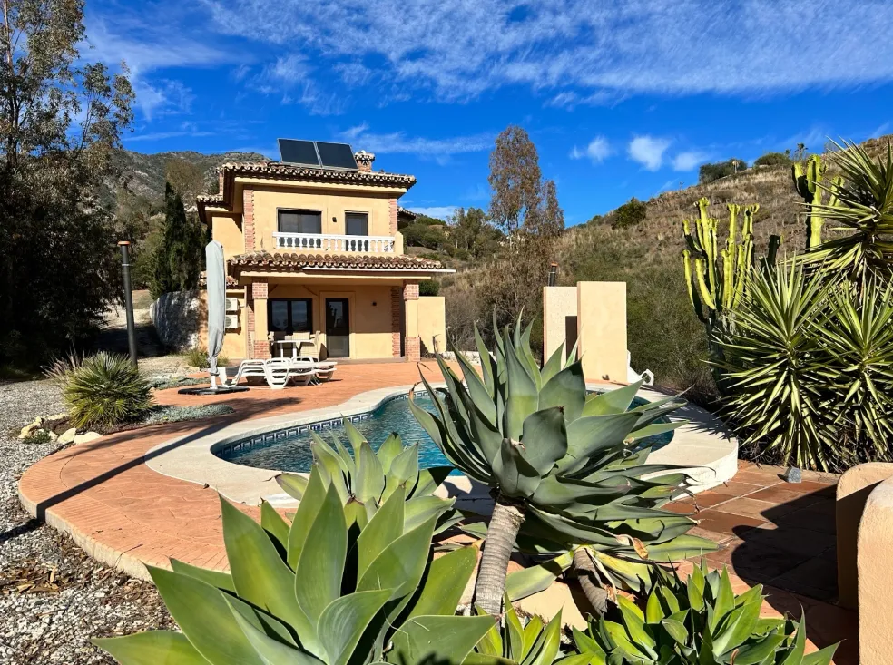 Casa de retiro en Mijas con piscina, vegetación mediterránea y vistas a la montaña.
